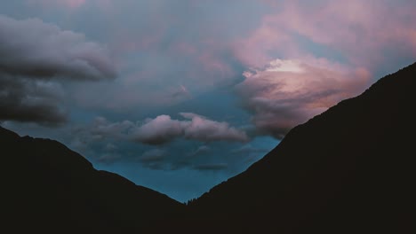 cinemagraph time lapse of clouds rolling across mountains at sunset