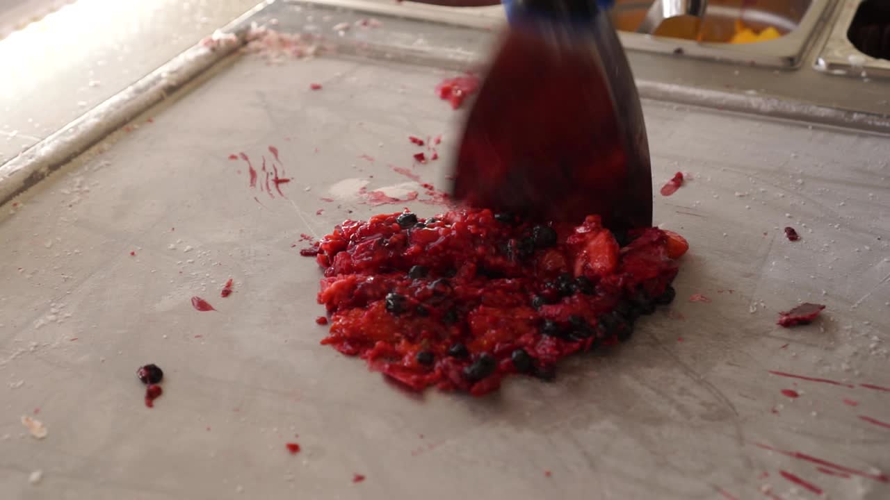 slowmo - picar y preparar dulces hechos a mano de fresas, arándanos, moras, postres de helado enrollados salteados al estilo tailandés en el festival de comida