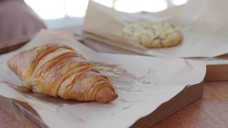 croissant and cookie on a wooden tray