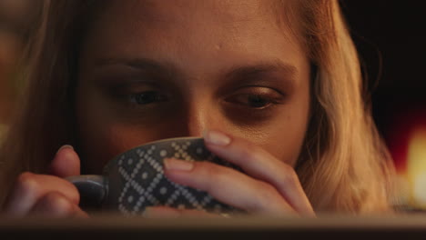 retrato de cerca de una mujer hermosa usando una tableta viendo una película por la noche disfrutando de entretenimiento en línea bebiendo café en casa