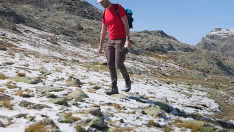 professional photographer walks on first snow in the mountains of italy