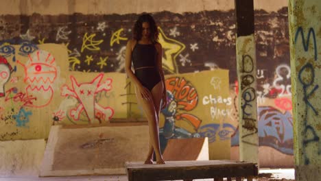 inside a building covered in graffiti, a young girl in a bikini finds fun and enjoyment