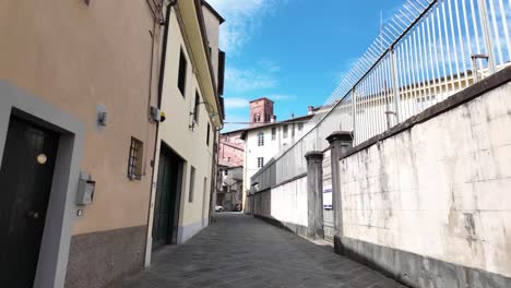 a narrow street with buildings and a fence