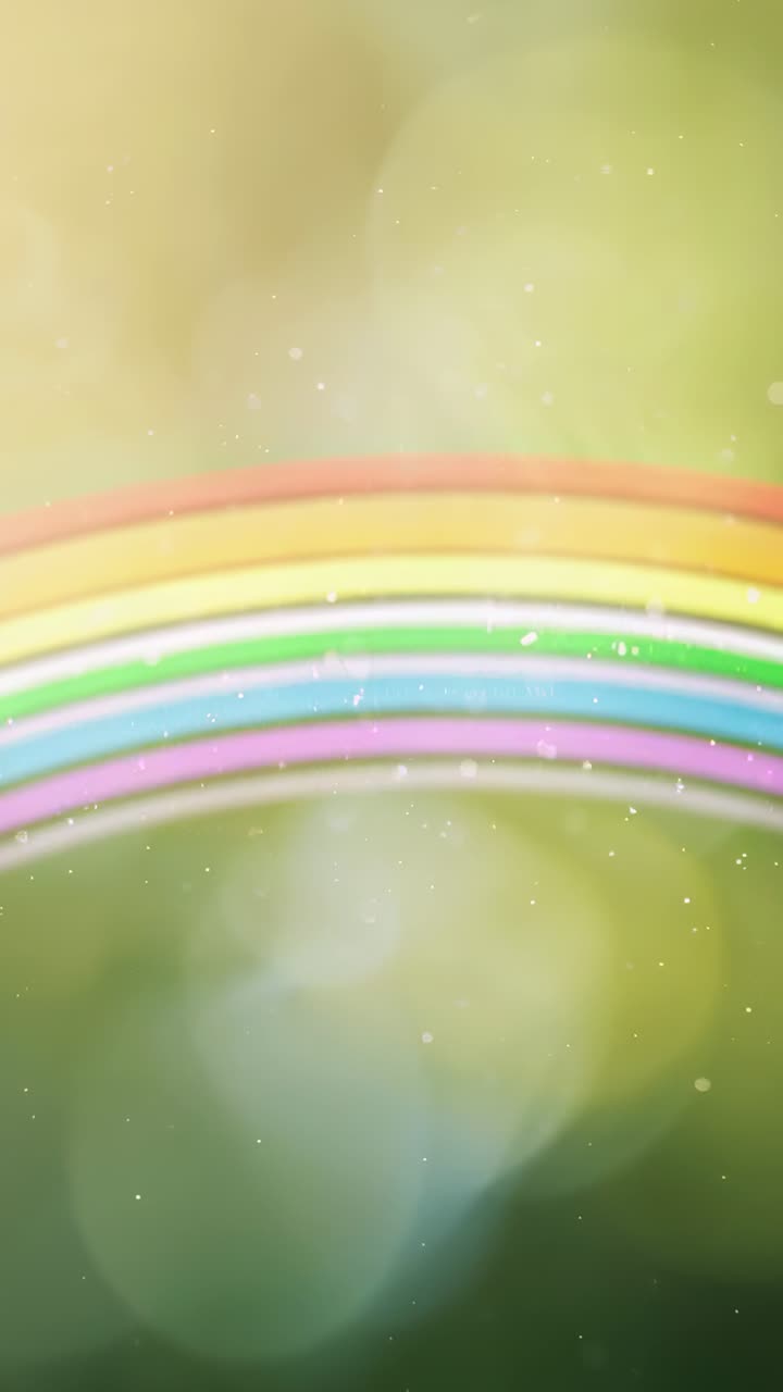 Video vertical: Un arcoíris pastel animado moviéndose hacia el centro sobre un resplandor verde, con chispas bokeh.