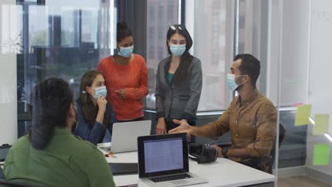 Eine-Vielfältige-Gruppe-Von-Arbeitskollegen-Mit-Gesichtsmasken-Diskutiert-Im-Besprechungsraum