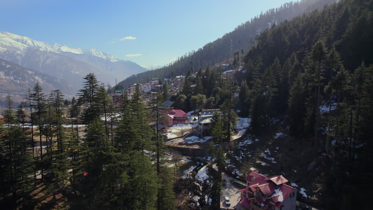 Góra wyłaniająca się zza drzew, ujęcie z drona w zaśnieżonych górach Himachal Pradesh w Indiach