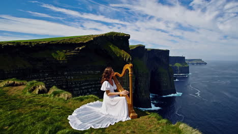 woman playing harp on the cliffs of moher overlooking the ocean