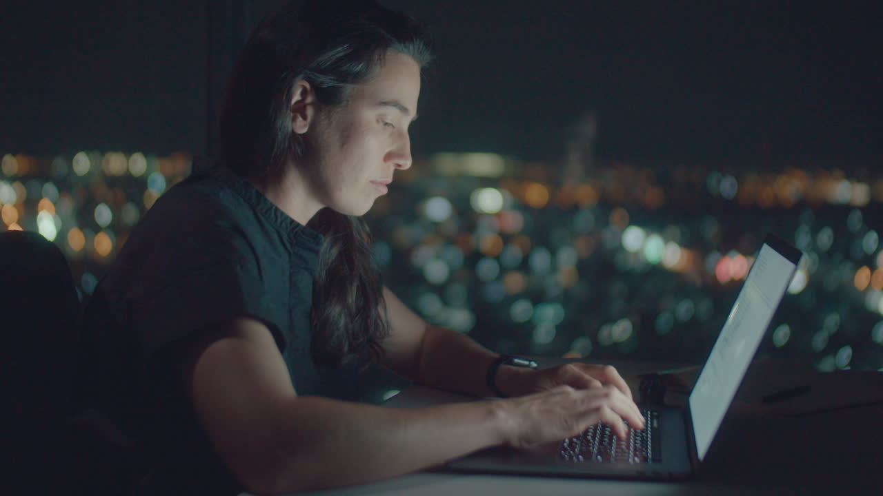 European woman typing text at night
