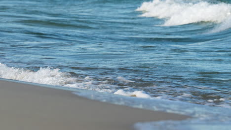 gentle sea waves lapping on a sunlit sandy beach