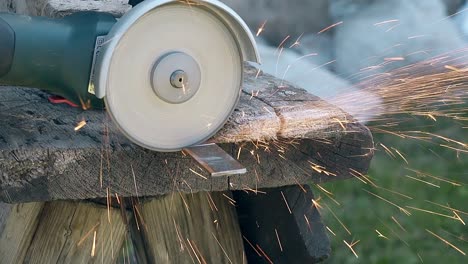 slow motion closeup cirkelzaag snijdt metalen plank bij vonken