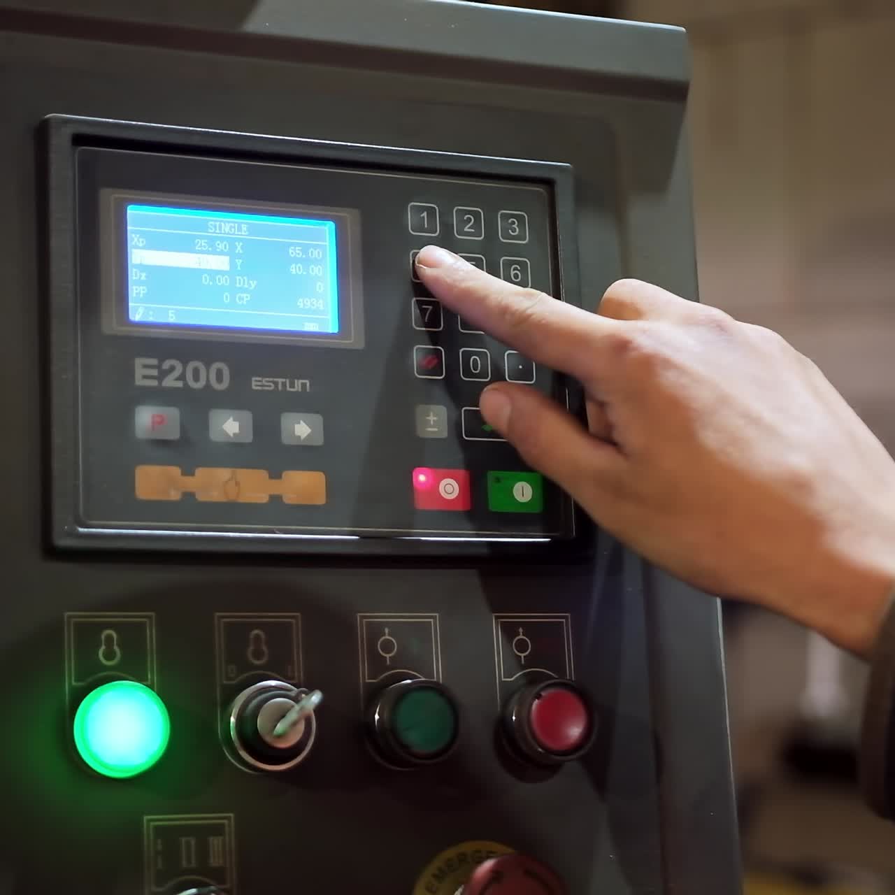Hand pushing the button on factory panel. Side view of male hand pushes the control panel buttons during a factory workflow. Industry indoors.Close-up.