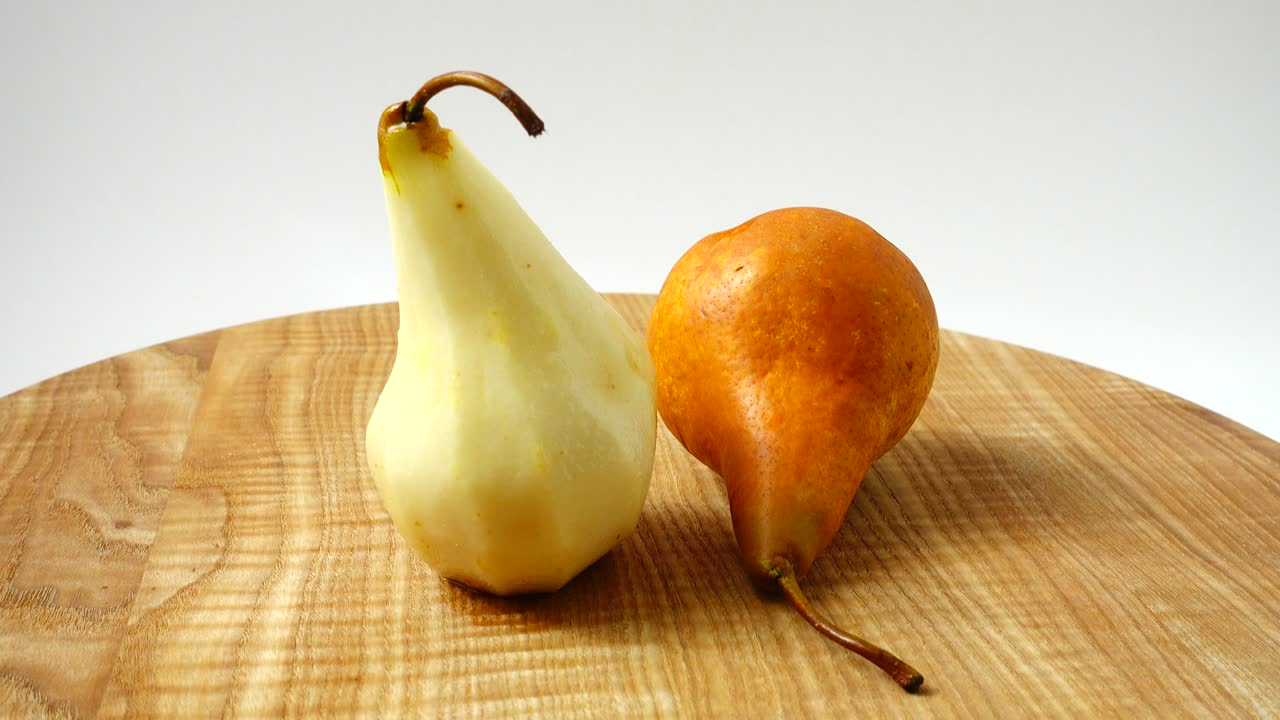 Pere su un tagliere di legno in cucina. Ripresa in movimento