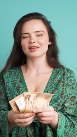 rich woman showing euro banknotes in blue studio