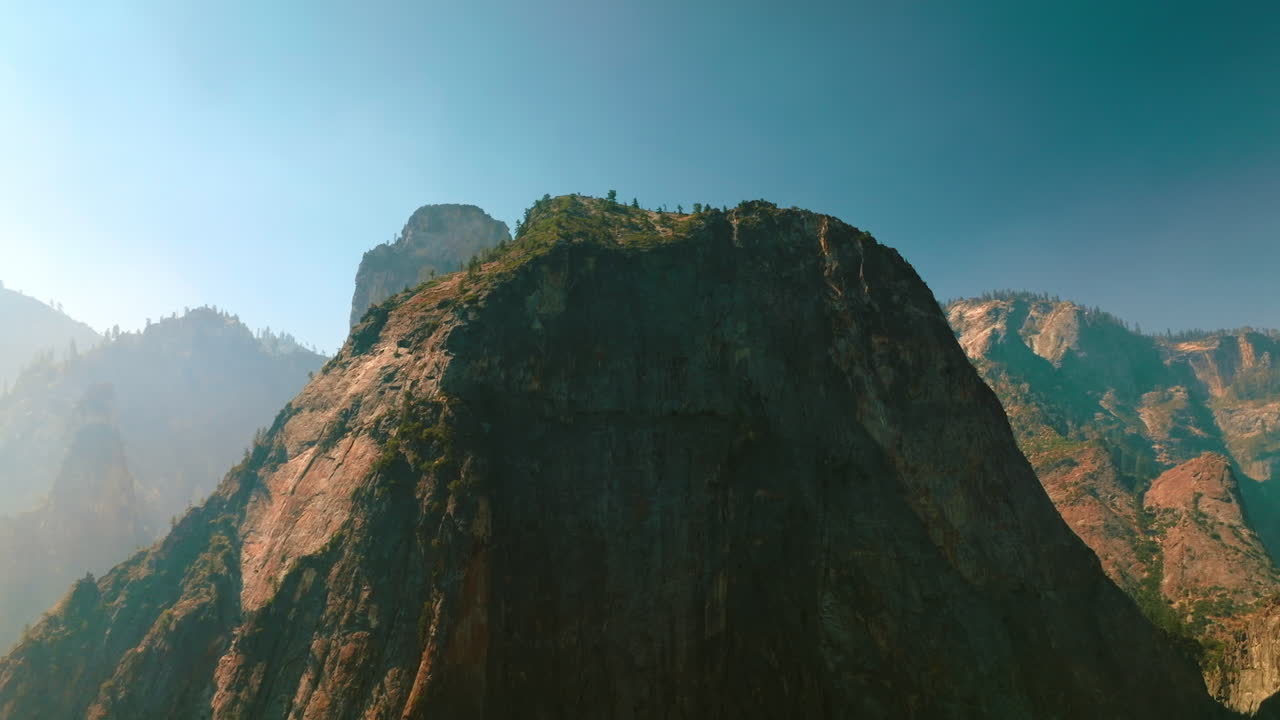 Picturesque rock of Yosemite National Park, California, USA. Beautiful mountain with some trees growing on top. Clear sky at backdrop.