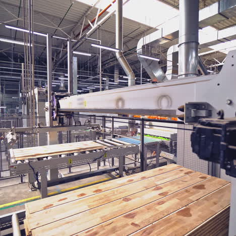 special automatic equipment shifts wooden boards on a pallet in the workshop. woodworking factory.