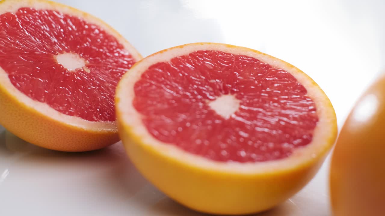 Slow motion Dolly in and out over Sliced Grapefruit on white table, Citrus fruit Concept