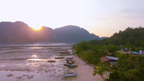sunset over a tropical island beach with boats and resorts