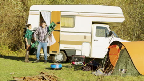 beautiful young couple getting out of their retro camper van