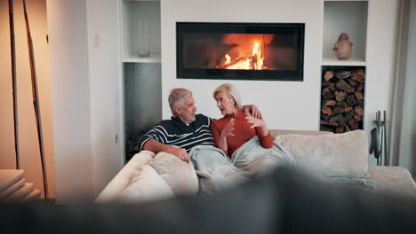 elderly couple relaxing by the fireplace