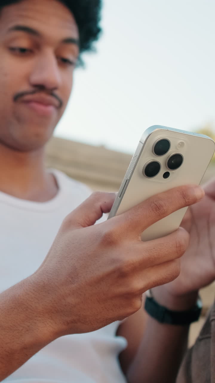Young Man Browsing Content on his Smartphone Outdoors