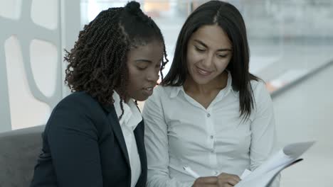 smiling businesswomen signing contract