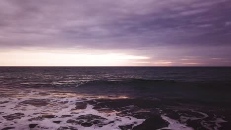 beautiful purple over the waves of ecuador by olon beach -low aerial