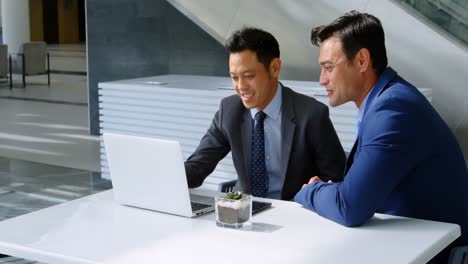 Businessmen-discussing-over-laptop-on-table-4k