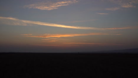 Zeitraffer-Eines-Lebhaften-Sonnenuntergangs-über-Dem-Feld