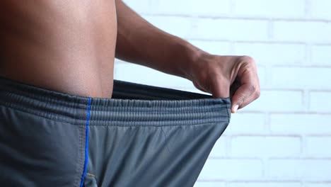 man showing loose shorts - weight gain