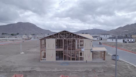 el dron se retira para revelar una casa parcialmente construida en un día nublado