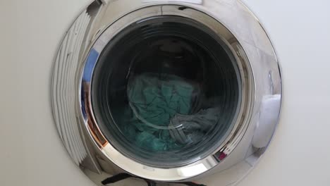 washing machine is running the program to wash the bed sheets in the afternoon, view from the porthole