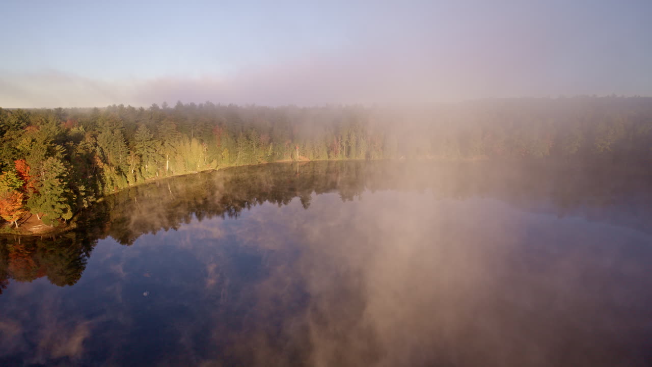 Cinematic shot from above showing mist rolling off water at daybreak