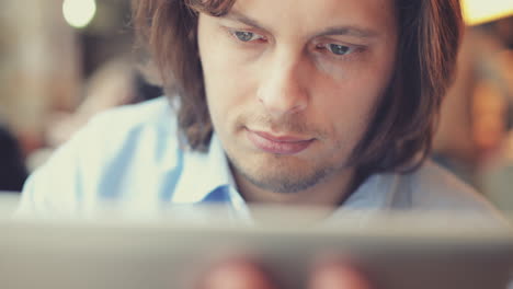 hombre usando una pantalla táctil de computadora en una cafetería