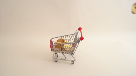 mano tomando una moneda en un carrito de compras