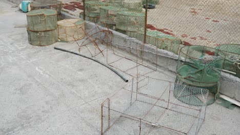 Empty-fishing-nets-laying-around-at-old-harbour,-fishing-equipment