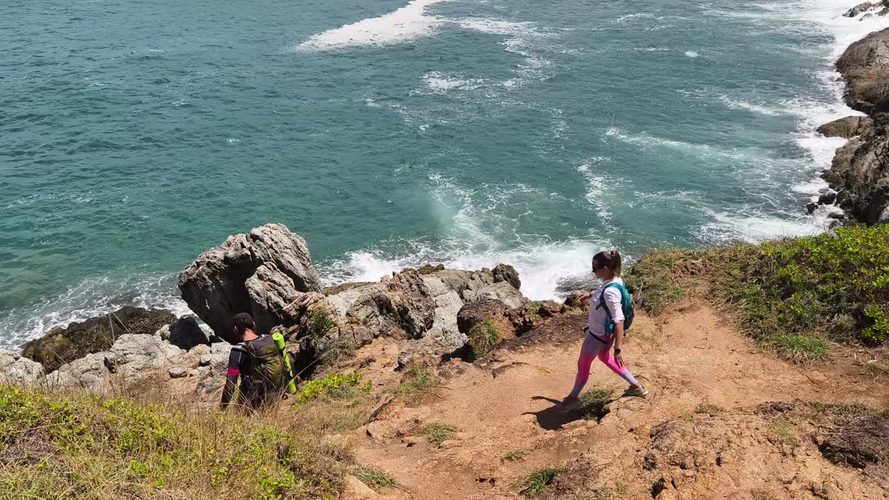 Hikers on a Rocky Coastline