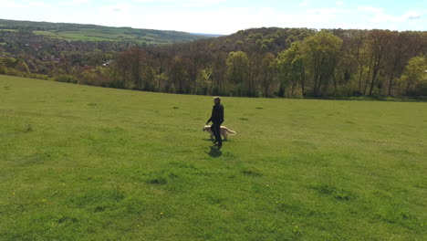 Aerial-Shot-Of-Mature-Man-With-Dog-On-Walk-In-Countryside