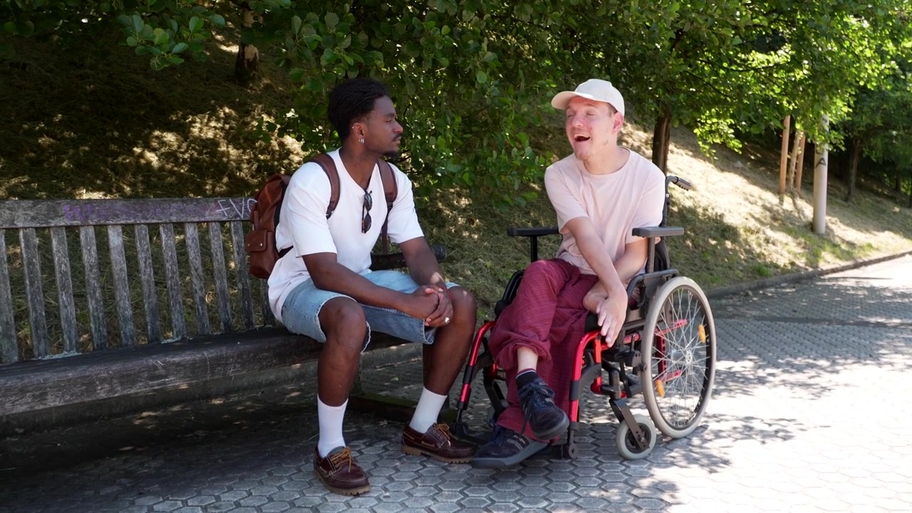 Due giovani uomini che conversano amichevolmente in un parco
