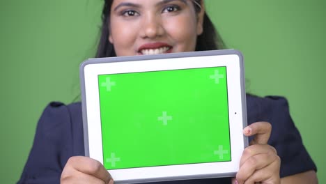 joven sobrepeso hermosa mujer de negocios india contra fondo verde