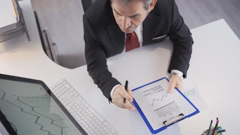 Geschäftsmann-Führt-Finanzanalyse-Auf-Dem-Diagramm-In-Seiner-Hand-Durch.