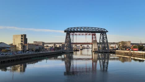 Wide-Pan-Of-Puente-Transbordador-And-Red-Bridge-Behind-It,-Buenos-Aires