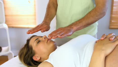 terapeuta realizando reiki en el paciente