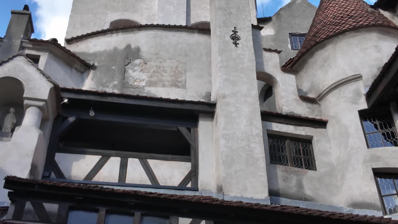 Upward pan from the inner courtyard of Bran Castle, revealing the surrounding stone walls and medieval design