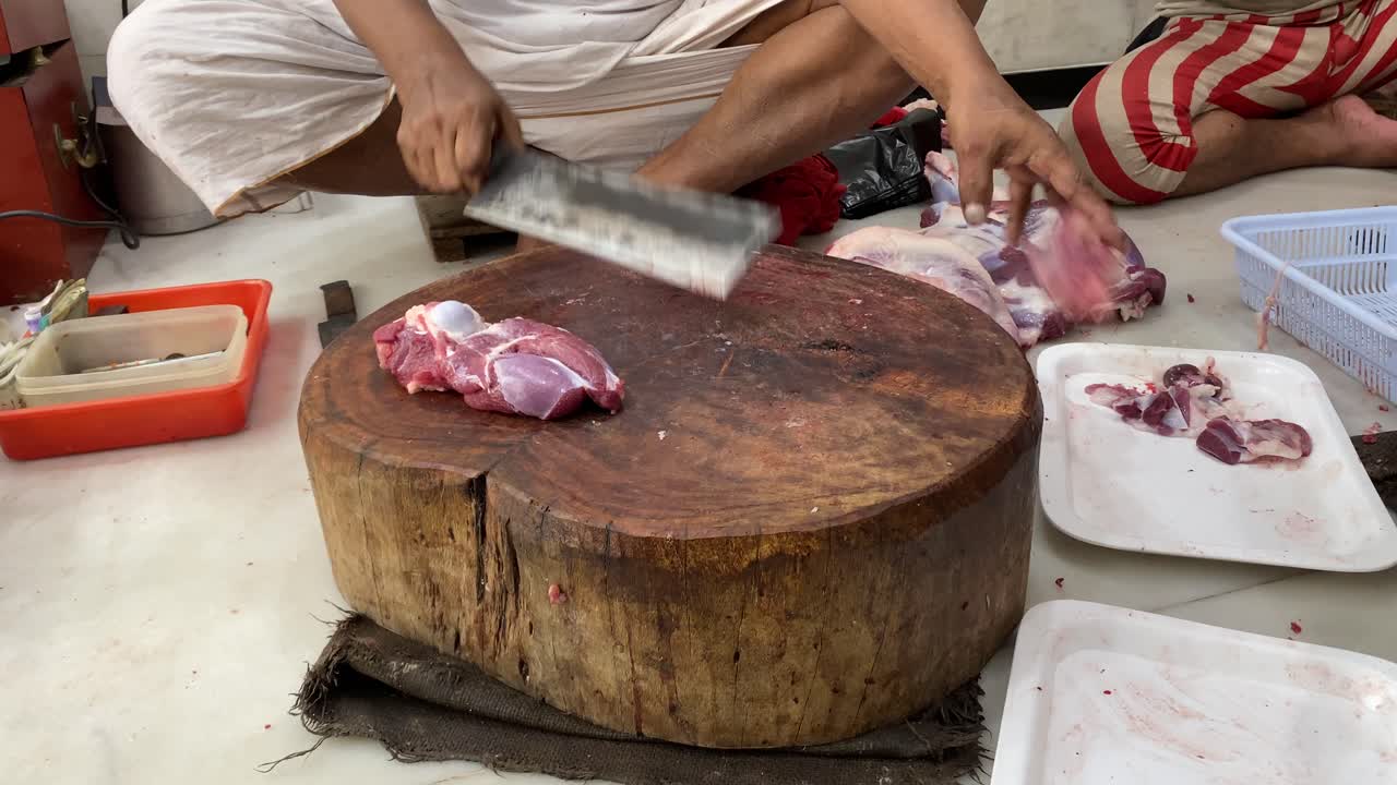 Close up shot of a butcher in India counting money (rupees) for trading raw meat for kebabs.