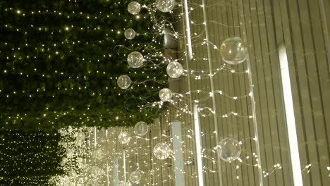 vertical shot of christmas shopping mall lights attached to ceiling, handheld