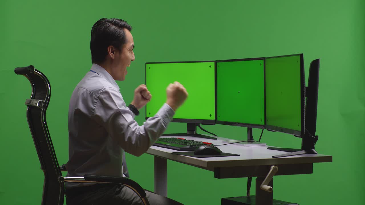 녹색 스크린 앞에서 성공을 축하하는 남자