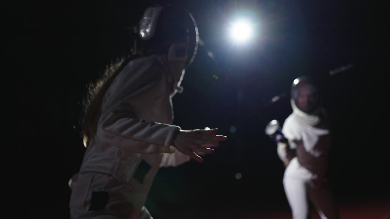 due schermatori che indossano uniformi bianche competono in una partita di scherma