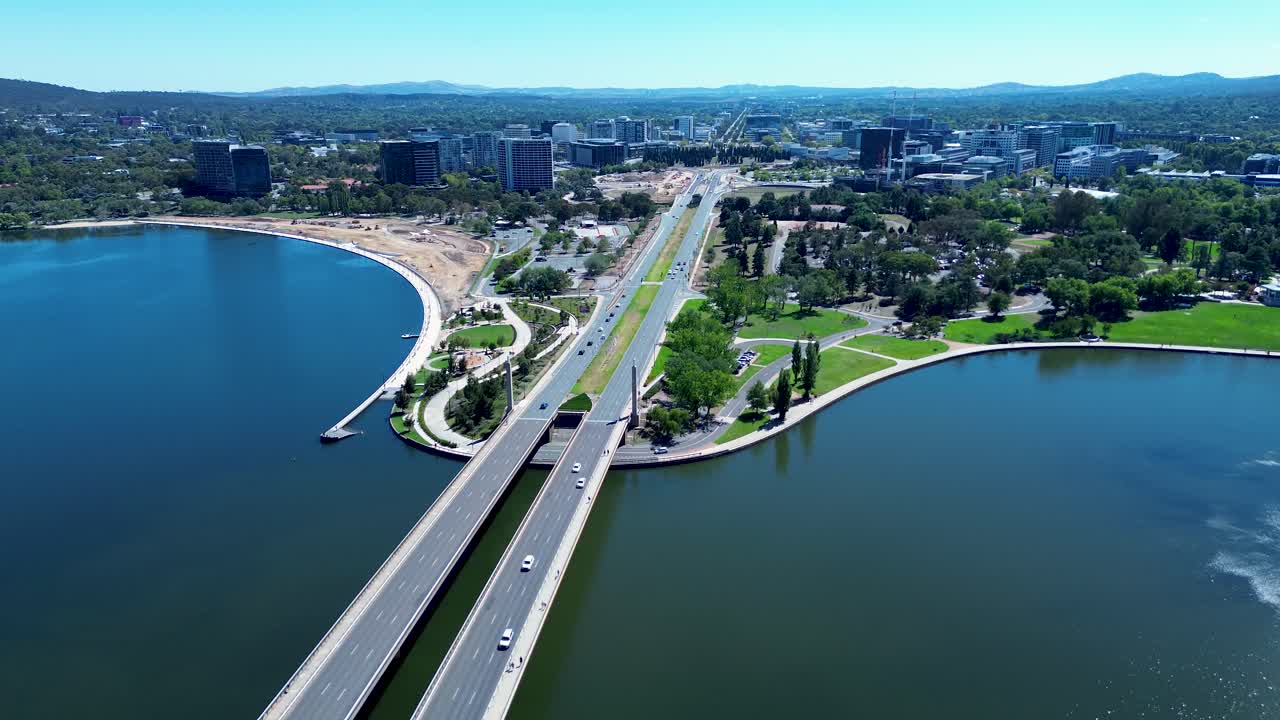 Drone aerial landscape of car vehicles traffic driving across bridge overpass road highway over Lake Burley Griffin Molonglo river in Canberra city capital ACT Australia travel transport urban tourism