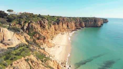 Secluded-sand-beach-surrounded-by-cliffs,-Lagos,-Algarve