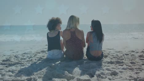 multiple star icons over rear view of three diverse female friends sitting and talking on the beach